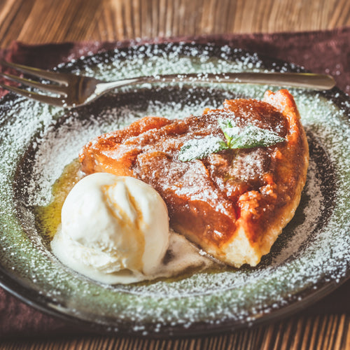 Tarte Tatin Waxmelt – geurblokje van sojawas met appel, bruine suiker, tonkaboon, vanille en karamel. Foto van tarte tatin taartpunt met poedersuiker en bolletje ijs.