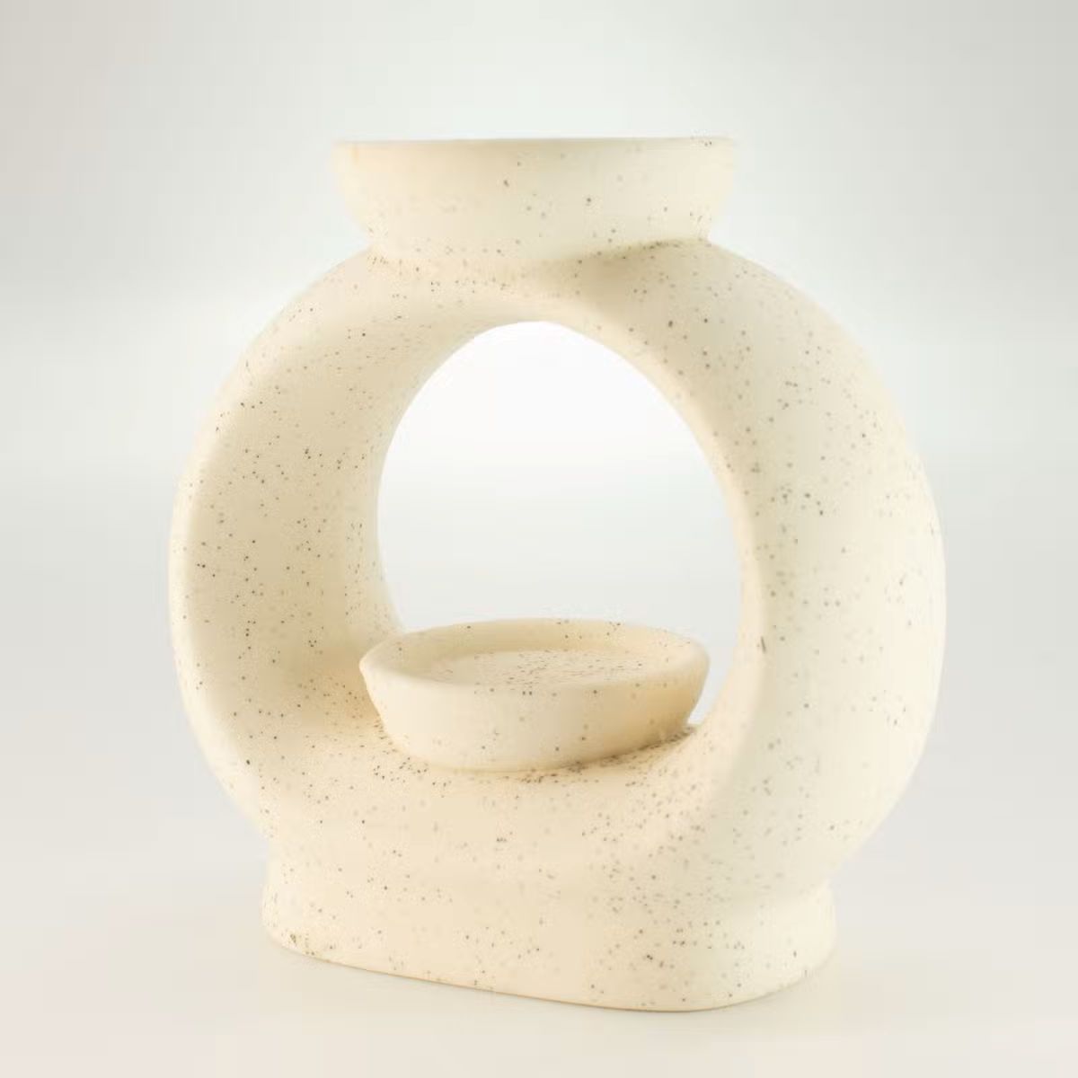 Keramische Zen geurbrander in warme crèmekleur met subtiele spikkels en open ovaal design.