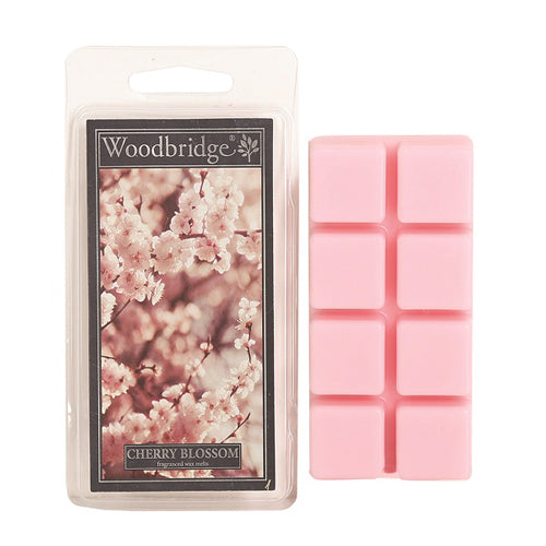 Woodbridge Cherry Blossom Wax Melts – bloemige geur van kersenbloesem, jasmijn en vanille. Foto van verpakking met roze waxblokjes en bloesemtakken.
