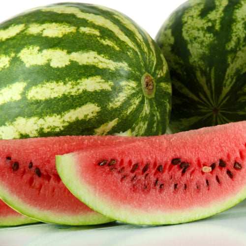 Aangesneden watermeloen naast een handgemaakte sojawas-waxmelt in zomerse sfeer