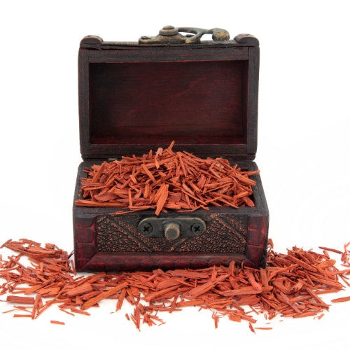 Sandalwood Waxmelt – geurblokje van sojawas met houtachtige, warme en rustgevende tonen. Foto van een houten kistje gevuld met sandelhout snippers.