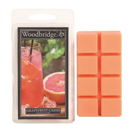 Grapefruit Cassis Wax Melts Woodbridge – fruitige geurblokjes met citrus, zwarte bes en vanille. Foto van oranje wax melts en een glas grapefruitdrank.