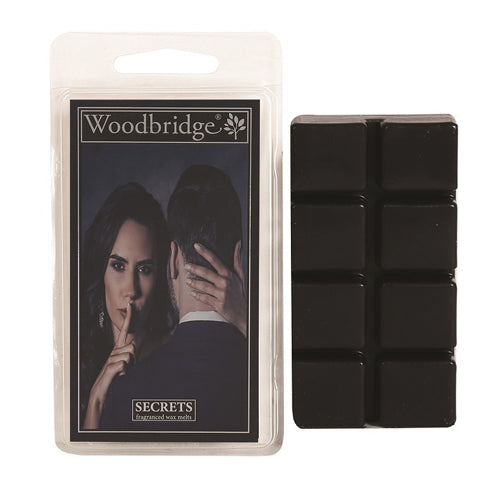 Secrets Wax Melts Woodbridge – luxe geurblokjes met appel, bloemen en suède. Foto van zwarte wax melts met verpakking met een stijlvol en mysterieus design.