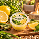 Citronella Waxmelt van Pure Scents in transparant potje met frisse citroenen, citronellagras en een sfeervol brandend kaarsje.